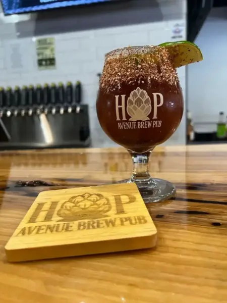 "Hop A Chelada Michelada in a branded glass with a spiced rim and lime at Hop Avenue Brew Pub in Bridge City."