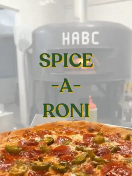 "Spice-A-Roni pizza in Bridge City, loaded with spicy pepperoni and fresh jalapeños in front of a brick oven."