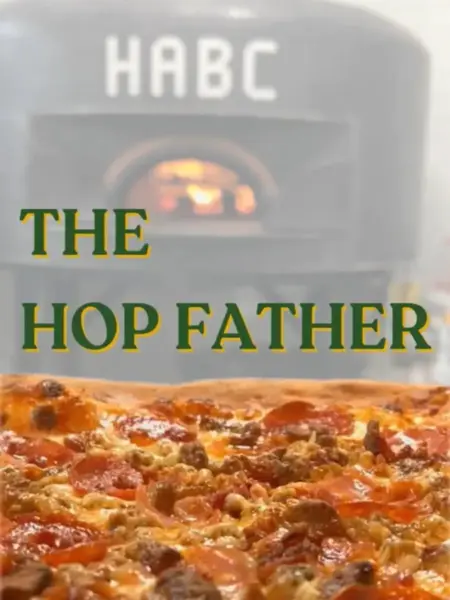 "The Hop Father meat lovers pizza in Bridge City, with crispy pepperoni and sausage in front of a glowing brick oven."