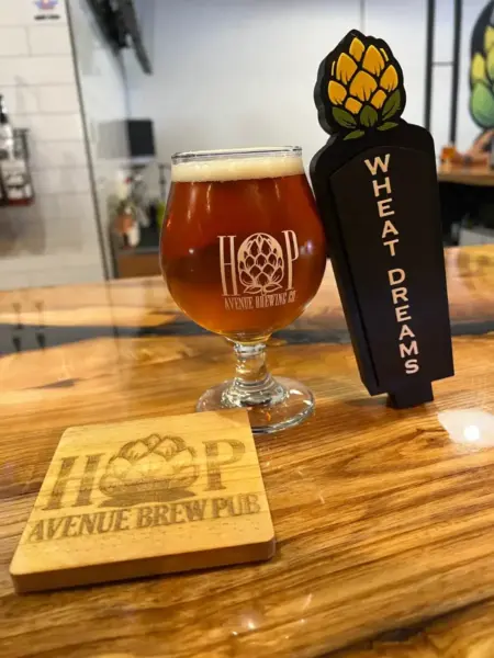 "Wheat Dreams American Pale Wheat Beer next to its custom tap handle at Hop Avenue Brew Pub in Bridge City."